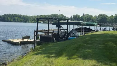 a dock with chairs and a boat on a lake at Milton's Cottage in Lake Milton