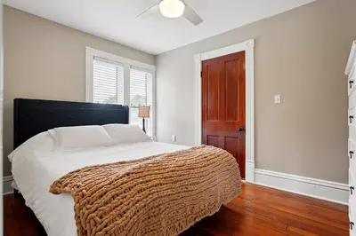 a bedroom with a bed with a brown blanket on it at The Victorian House in Canfield