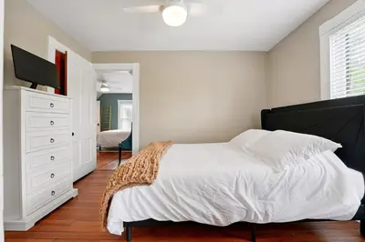 a bedroom with a bed and a dresser with a television at The Victorian House in Canfield