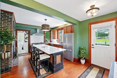 a kitchen with green walls and a white counter top at The Victorian House in Canfield