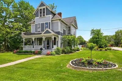 a house with a flower bed in the yard at The Victorian House in Canfield