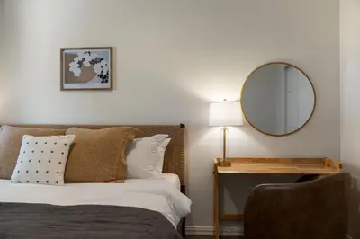 a bedroom with a bed with a mirror and a chair at Stunning 2 BR - Parking and Walk to Park in Columbus
