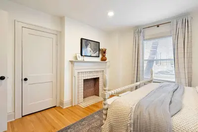 a white bedroom with a fireplace and a bed at Close to OSU Rooftop Patio Grill & Outdoor TV in Columbus