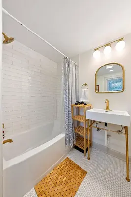 a bathroom with a tub and a sink and a mirror at Close to OSU Rooftop Patio Grill & Outdoor TV in Columbus