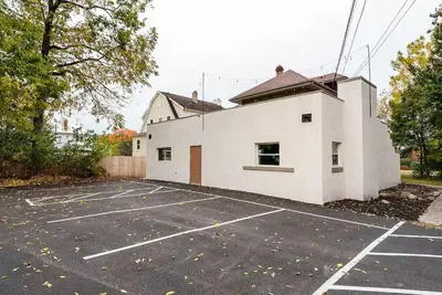 an empty parking lot with a white building at Close to OSU Rooftop Patio Grill & Outdoor TV in Columbus