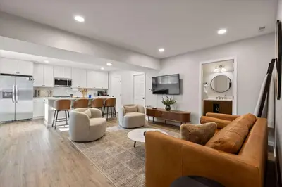 a living room with a couch and a kitchen at Clintonville Brand New Apartment in Columbus