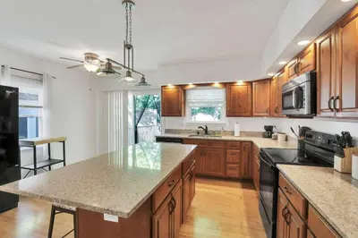 a kitchen with wooden cabinets and a counter top at The Meadow Adventure in Columbus