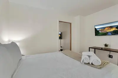 a white bedroom with a bed with two towels on it at The Meadow Adventure in Columbus