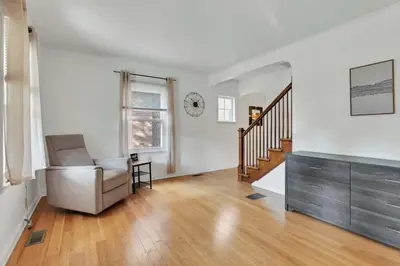 an empty living room with a chair and a staircase at The Meadow Adventure in Columbus