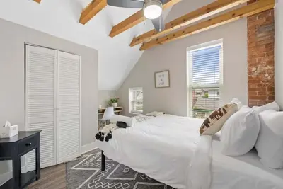 a bedroom with a large white bed and a brick wall at Sophisticated Boho Condo Walkable Columbus in Columbus