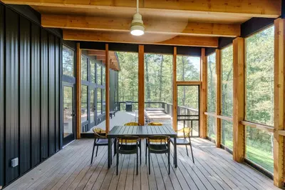 a dining room with a table and chairs on a deck at The Hollow House in McArthur