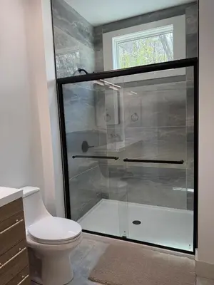 a bathroom with a glass shower with a toilet at The Hollow House in McArthur