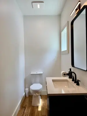 a bathroom with a white toilet and a sink at The Hollow House in McArthur