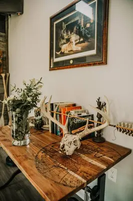 a wooden table with a vase and antlers on it at The Honey Hut Think of On Golden Pond in Mount Sterling