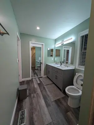 a bathroom with a toilet and a sink and a mirror at CulDeSec Home 4BR 3 & half Baths Sleeps 7 Jacuzzi tub in Columbus