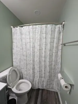 a bathroom with a toilet and a shower curtain at CulDeSec Home 4BR 3 & half Baths Sleeps 7 Jacuzzi tub in Columbus