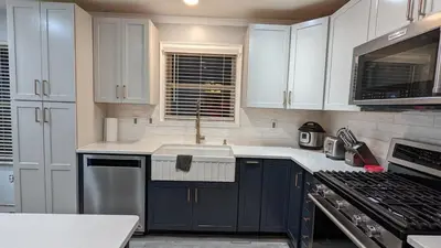 a kitchen with white cabinets and a sink and a stove at CulDeSec Home 4BR 3 & half Baths Sleeps 7 Jacuzzi tub in Columbus