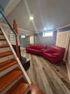 a living room with a red couch and stairs at CulDeSec Home 4BR 3 & half Baths Sleeps 7 Jacuzzi tub in Columbus