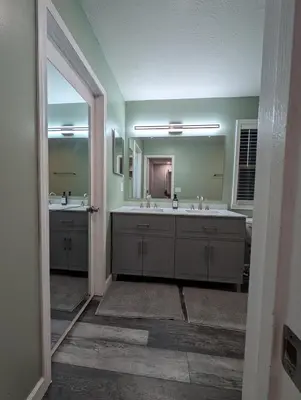 a bathroom with two sinks and a large mirror at CulDeSec Home 4BR 3 & half Baths Sleeps 7 Jacuzzi tub in Columbus