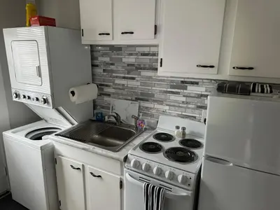 a kitchen with a stove and a sink and a refrigerator at Gem 1 Downtown Willoughby Historic District in Willoughby
