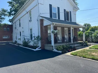 a white house with black shutters on a street at Gem 1 Downtown Willoughby Historic District in Willoughby