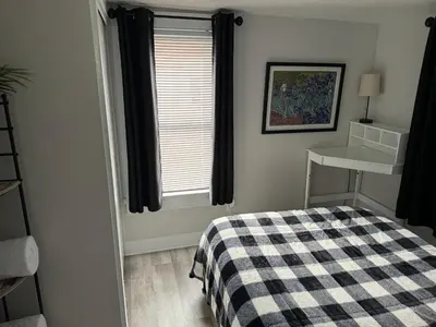 a bedroom with a checkered bed and a window at Gem 1 Downtown Willoughby Historic District in Willoughby