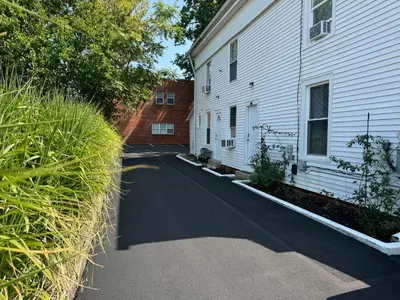 a house with a driveway next to a building at Gem 1 Downtown Willoughby Historic District in Willoughby