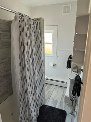 a bathroom with a shower curtain and a sink at Downtown Willoughby Historic District Gem 3 in Willoughby