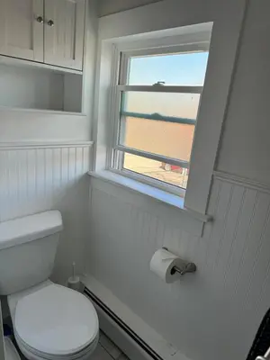 a bathroom with a toilet and a window at Downtown Willoughby Historic District Gem 3 in Willoughby