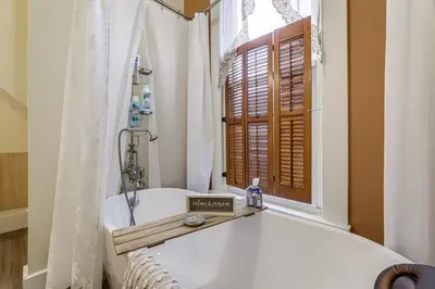 a bathroom with a bath tub and a window at Walkable Group Getaway with Bikes in West Liberty! in West Liberty