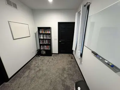 a hallway with a black door and a book shelf at Country Cornerstone Retreat Upstairs Apartment with Hot Tub, Jetted Tub, Sauna, Massage Chair, BBQ in Hillsboro
