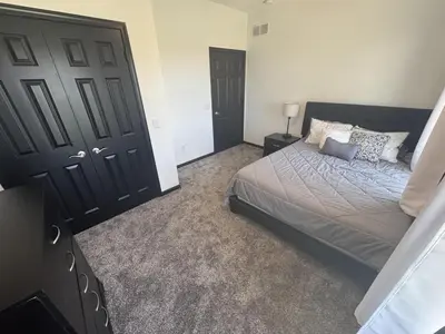 a bedroom with a bed and a large black door at Country Cornerstone Retreat Upstairs Apartment with Hot Tub, Jetted Tub, Sauna, Massage Chair, BBQ in Hillsboro
