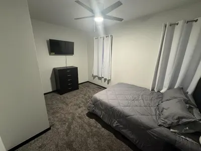 a bedroom with a bed and a flat screen tv at Country Cornerstone Retreat Upstairs Apartment with Hot Tub, Jetted Tub, Sauna, Massage Chair, BBQ in Hillsboro