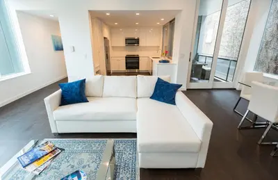 a living room with a white couch and blue pillows at Unique contemporary 1600ft2 2BR 3BA apt OTR in Cincinnati