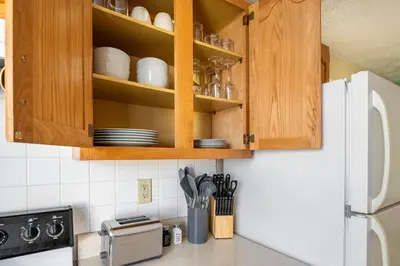 a kitchen with wooden cabinets and a white refrigerator at Pet-Friendly Serenity Spot on Dorthy Lane in Dayton