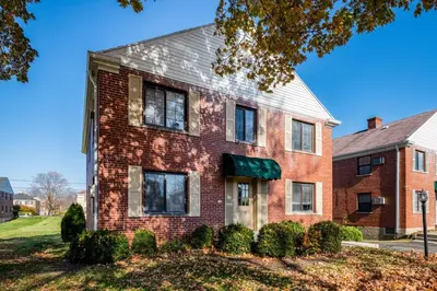 an older brick house with a green awning at Pet-Friendly Serenity Spot on Dorthy Lane in Dayton