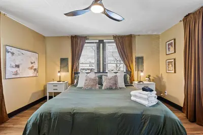 a bedroom with a green bed with a ceiling fan at The Luxe/Pickleball/Basketball/ Hot Tub/Horse Park in Georgetown