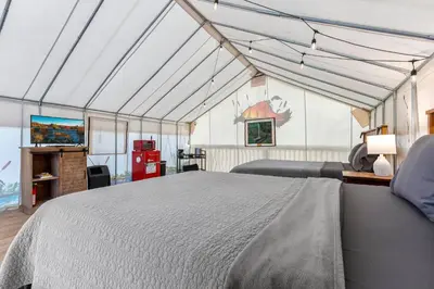 a bedroom with a large bed in a tent at Furnished Glamping Tent/River Access/2 Queen Beds in Stanton