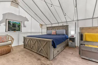 a bedroom with a bed and a chair in it at Furnished Glamping Tent/Red River Access/King Bed in Stanton