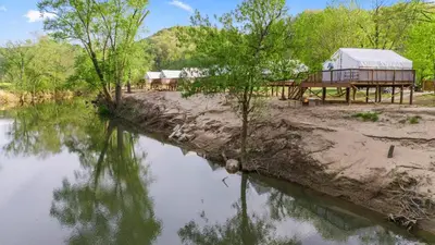 a view of a river with a building and trees at Furnished Glamping Tent/Red River Access/King Bed in Stanton