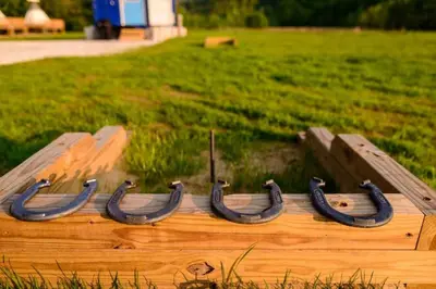 a wooden boat with black horseshoes in a field at Furnished Glamping Tent/River Access/2 Queen Beds in Stanton