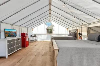 a room with two beds and a tv in a marquee at Glamping Tent/Red River Access/2 Queen Beds in Stanton