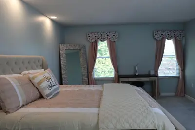 a bedroom with a large bed and two windows at Cozy Meets Luxury in Tylersville