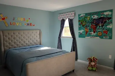 a bedroom with a bed and a map of the world at Cozy Meets Luxury in Tylersville