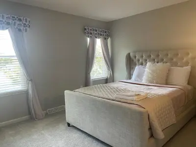 a bedroom with a large bed with two windows at Cozy Meets Luxury in Tylersville