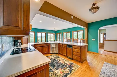 a large kitchen with green walls and wooden cabinets at Rural and Private Dover Retreat Close to Wineries! in Dover