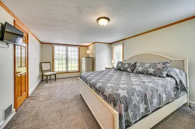 a bedroom with a large bed and a television at Rural and Private Dover Retreat Close to Wineries! in Dover