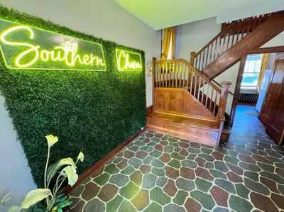 a room with a green wall with stairs and a sign at Southern Charm Private Queen Bedroom Suite 2 in Cincinnati