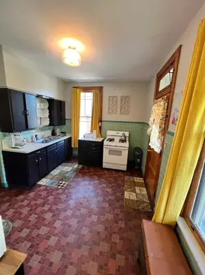 a kitchen with black cabinets and a white stove at Southern Charm Private Queen Bedroom Suite 2 in Cincinnati