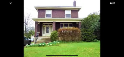 a red brick house with a grassy yard at Southern Charm Private Queen Bedroom Suite 2 in Cincinnati